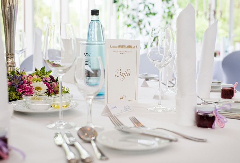 Nahaufnahme eingedeckter Tisch zur Hochzeitsfeier im Hotel Hohe Wacht, Teller, Besteck, Gläser, Wasserflasche, Buffetkarte, Namensschild, Blumendeko, Vorspeisenteller mit Öl, Butter und Dip für Brot