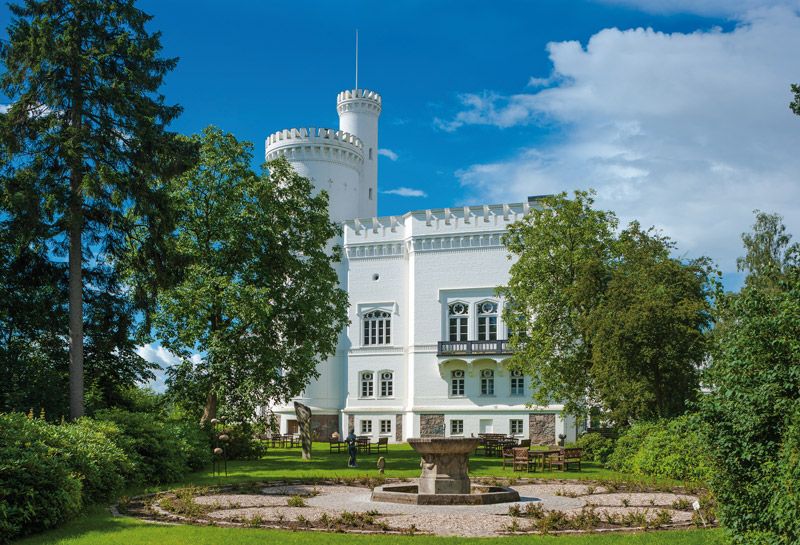 Aktivitäten Hotel Hohe Wacht, Schlösser und Herrenhäuser, Ansicht der Blomenburg, drumherum grüne Bäume, im Vordergrund Springbrunnen