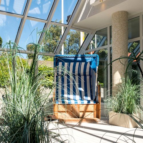 Wellness und Spa Hohe Wacht, Ruhebereich mit Strandkorb und Grünpflanzen, helle Fensterfront