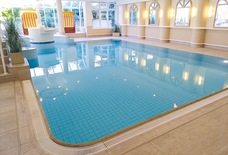 Wellnessbereich mit Schwimmbecken, im Hintergrund stehen Strandkörbe