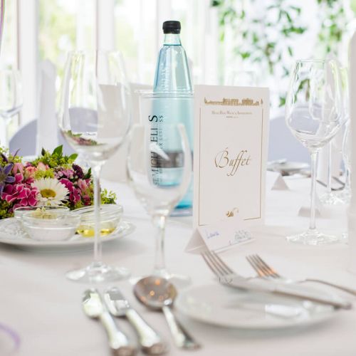 Nahaufnahme eingedeckter Tisch zur Hochzeitsfeier im Hotel Hohe Wacht, Teller, Besteck, Gläser, Wasserflasche, Buffetkarte, Namensschild, Blumendeko, Vorspeisenteller mit Öl, Butter und Dip für Brot