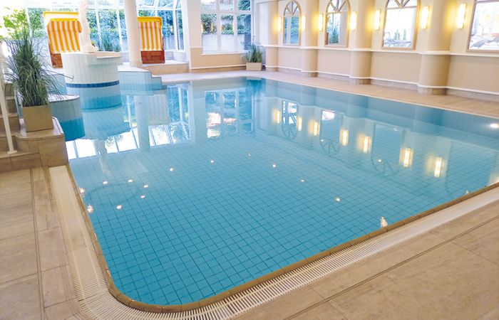 Wellnessbereich mit Schwimmbecken, im Hintergrund stehen Strandkörbe