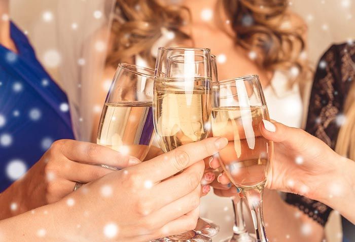 Gäste stoßen mit Champagnergläsern auf den Jahreswechsel an