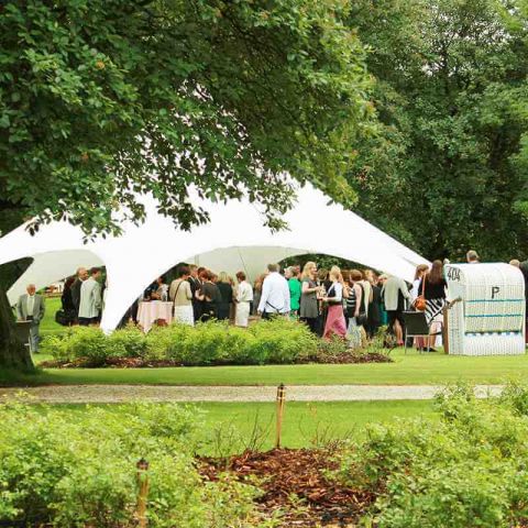 Sttrandkörbe und offener weißer Pavillion mit Stehtischen im grünen Kurpark Hotel Hohe Wacht, darunter Gesellschaft, Personal bedient