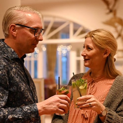 lächelndes Pärchen Mann und Frau an der Bar im Hotel Hohe Wacht, stoßen mit Granini Limonaden an