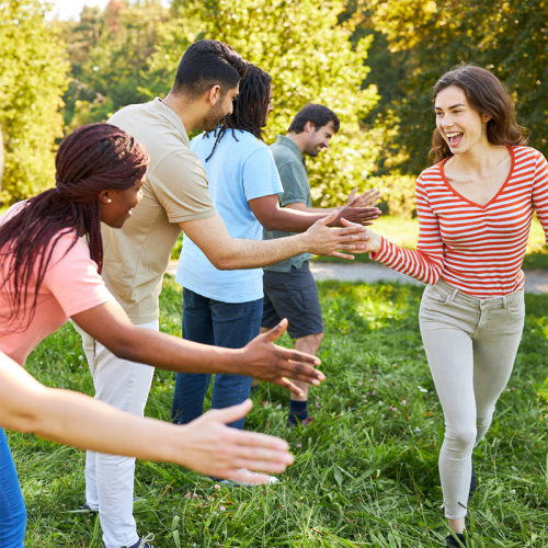 Gruppe von Personen im Grünen, die sich abklatschen