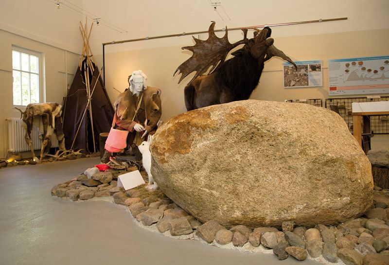 Schlösser und Herrenhäuser, Eizeitmuseum Lütjenburg, Ausstellung, im Vordergrund großer Findling, nachgestellte Tiere